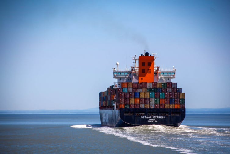 Un barco que transporta contenedores está en el mar.