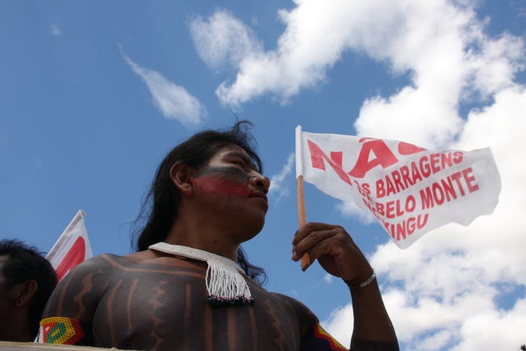 hombre vestido de indígena con bandera