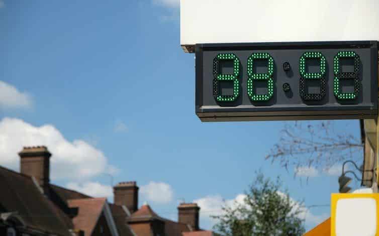 Un termómetro digital frente a una hilera de casas marcaba 38°C.