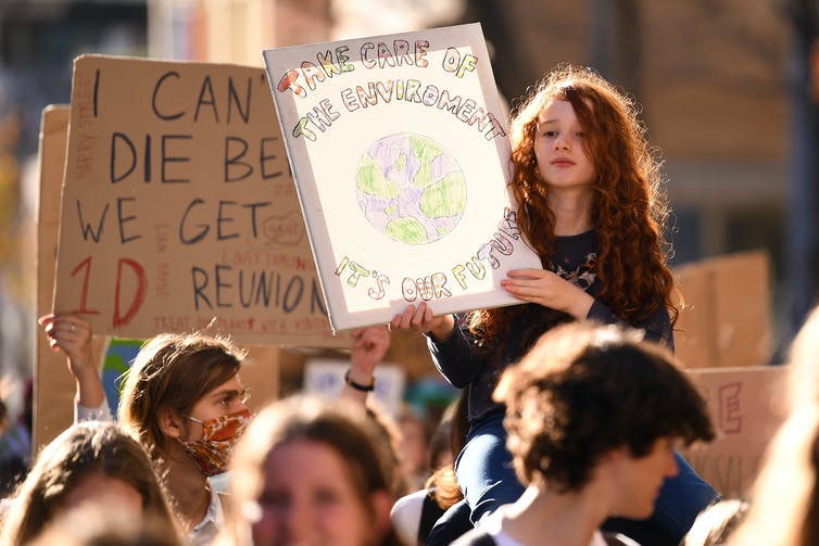 Un joven estudiante sostiene un cartel durante una protesta climática