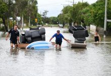 Hombre hace flotar muebles en agua de inundación