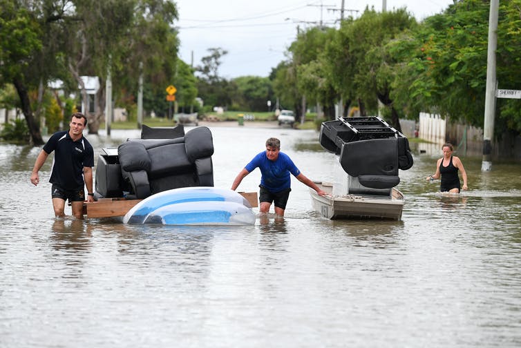 Hombre hace flotar muebles en agua de inundación