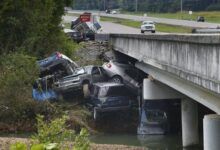 Varios coches y una gran camioneta fueron arrastrados río abajo por la inundación y amontonados en un puente.