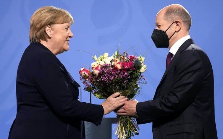 Un hombre que llevaba una máscara médica entregó flores a una mujer frente al podio
