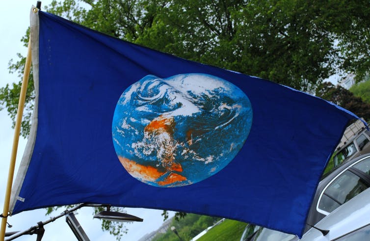 Bandera con todo el mundo sobre fondo azul.