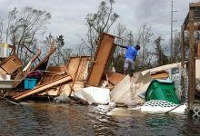 Un joven camina entre muebles y enseres domésticos esparcidos por un huracán para rescatar las pertenencias de su madre.