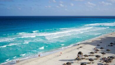 Playa con sombrilla y mar azul.