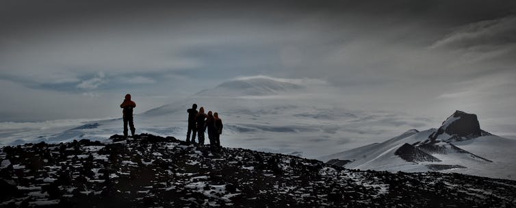 La gente se para en una cresta en la Antártida.