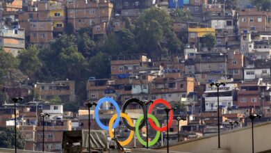 Un conjunto de anillos olímpicos frente a los barrios marginales de Río.
