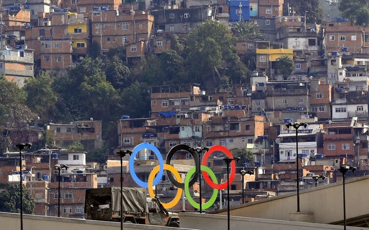 Un conjunto de anillos olímpicos frente a los barrios marginales de Río.