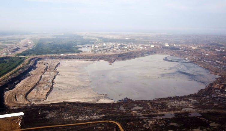 Fotografía aérea de un gran lago rectangular de residuos mineros.