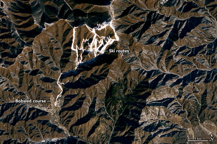 Vívidas líneas blancas grabadas en una gran franja de montañas marrones delinean rutas de esquí y trineos.