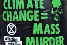 Un cartel de Extinction Rebellion que dice 'Cambio climático = asesinato masivo'