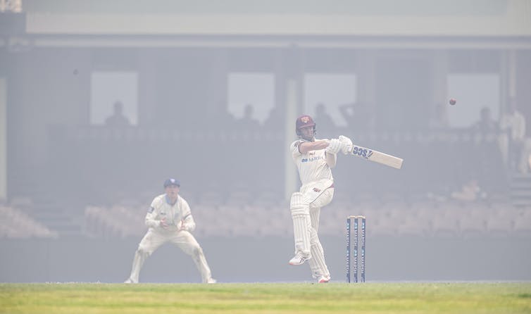 jugadores de críquet jugando mientras el humo de los incendios forestales llena el suelo