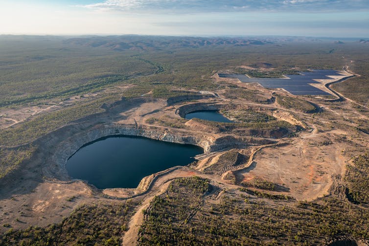 Vista aérea de dos embalses y paneles solares en un paisaje seco para un proyecto de almacenamiento hidroeléctrico por bombeo