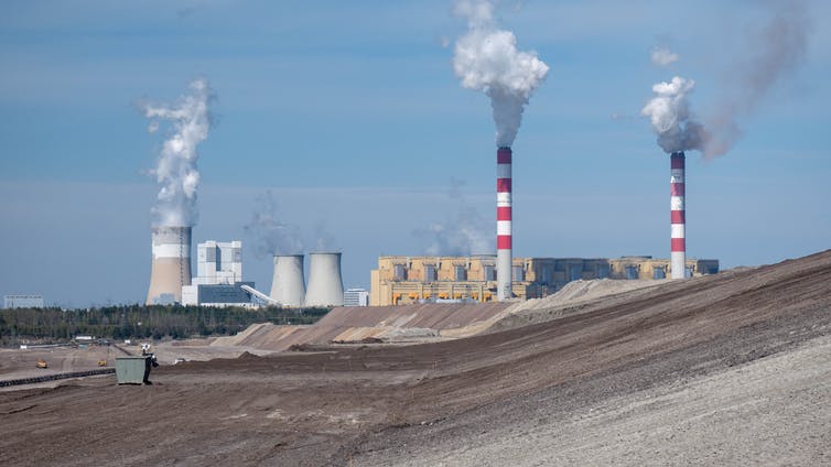 Una central eléctrica con chimeneas que emiten humo.