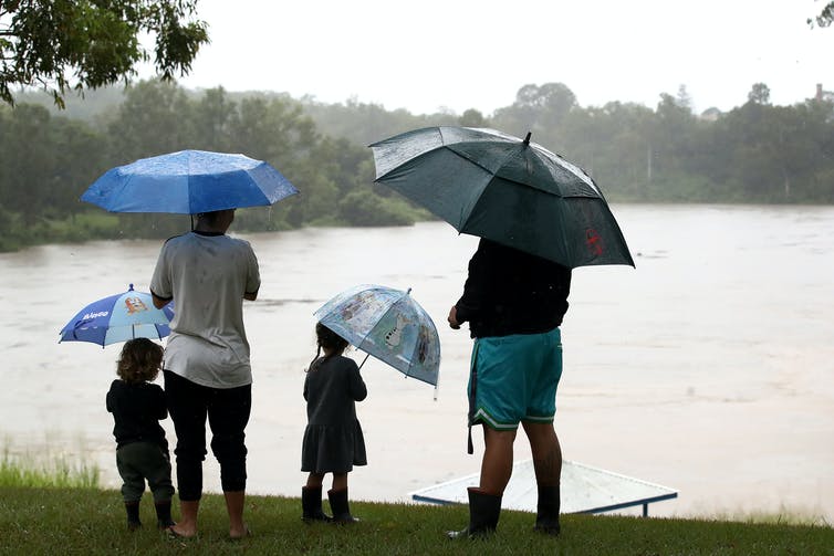 Dos padres y dos niños observan el aumento de las inundaciones
