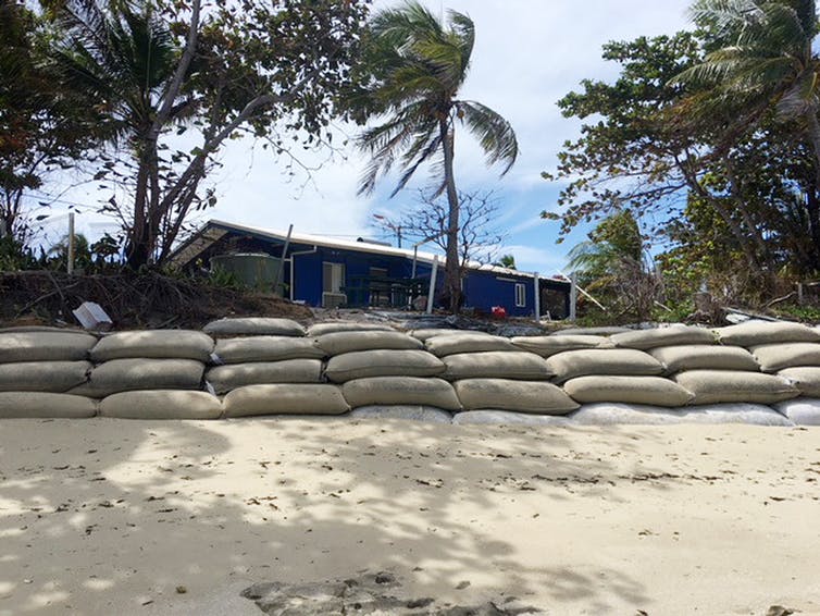 Un muro de sacos terreros de un metro de altura separa la playa de las casas del Estrecho de Torres.