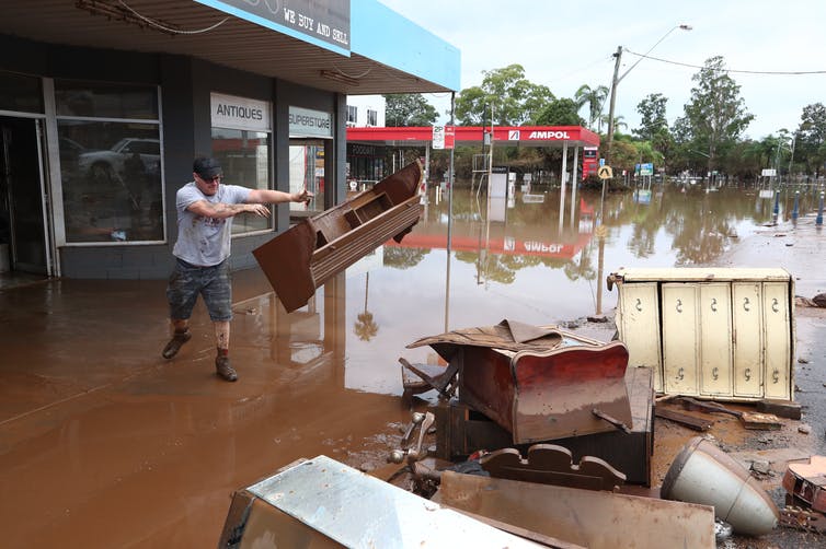 Hombre arroja muebles sobre montones en inundación