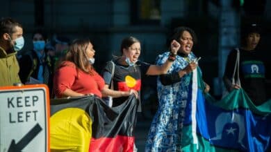 La gente sostenía banderas de aborígenes e isleños del Estrecho de Torres durante la protesta.