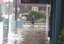 Dos personas caminando por una calle inundada