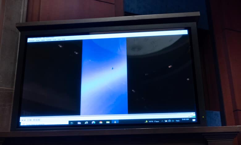 una imagen de una pantalla grande que muestra un video de un fenómeno aéreo no identificado durante una audiencia en el Congreso