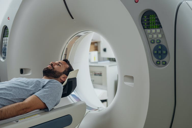 Hombre entrando en un escáner CT