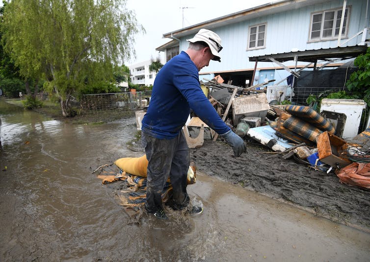 Hombre limpia después de la inundación de Townsville