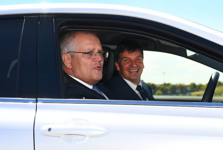 dos hombres sonrientes sentados en el auto