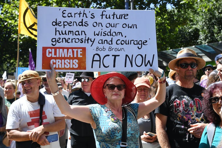 Mujer sostiene un cartel en una protesta climática