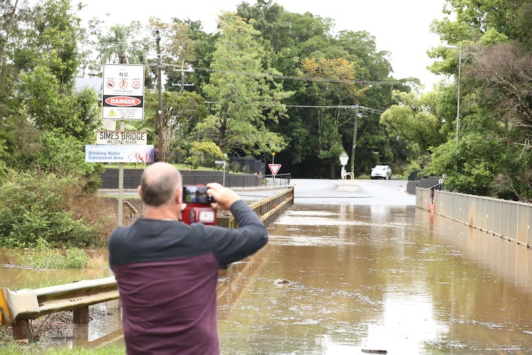 hombre fotografía camino inundado
