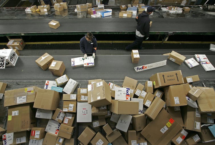 Un montón de cajas de varios tamaños listas para enviarse en un centro de distribución de envíos de FedEx.