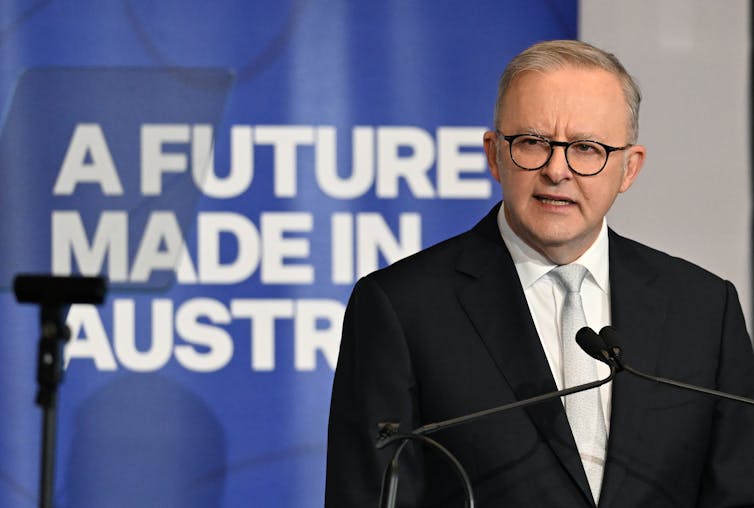 anthony albanese, hombre delante del cartel