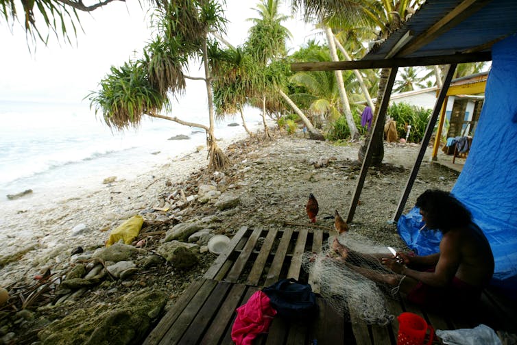 Un isleño se sienta en su casa cerca de la costa